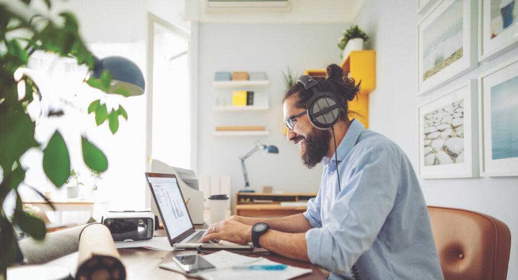Man wearing headphones working on laptop