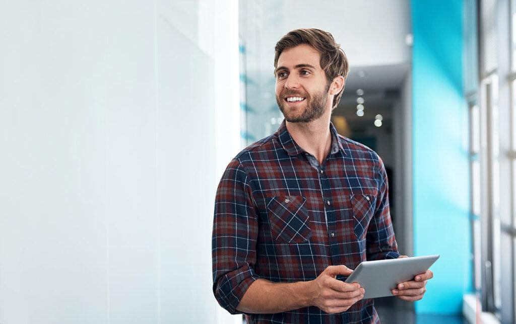 Man standing with iPad smiling