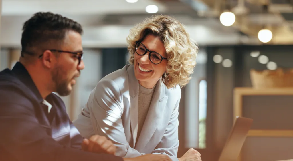 Two people sitting down office setting